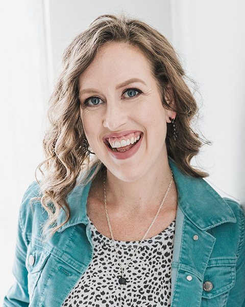 Kacey Birch, conversion copywriter, smiling in a teal jacket